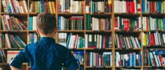 Boy standing in front of a shelf