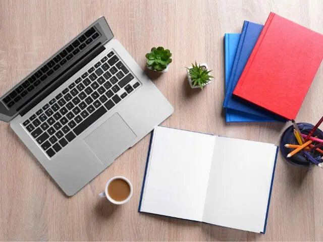 books and laptop on wooden table